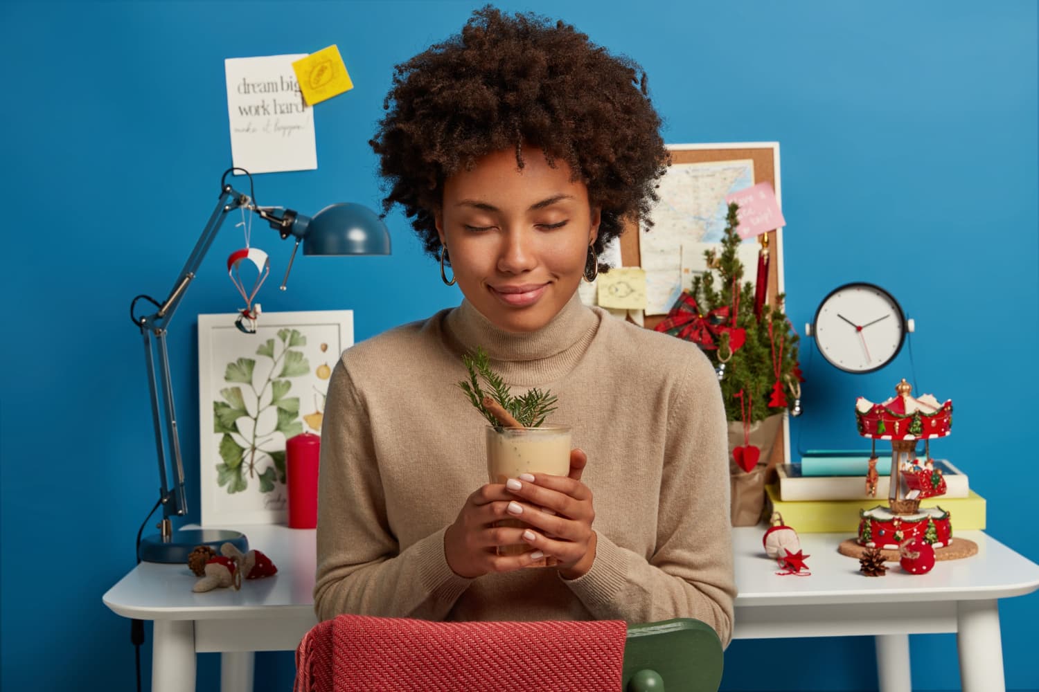 A woman enjoying a gift surrounded by wrapped presents